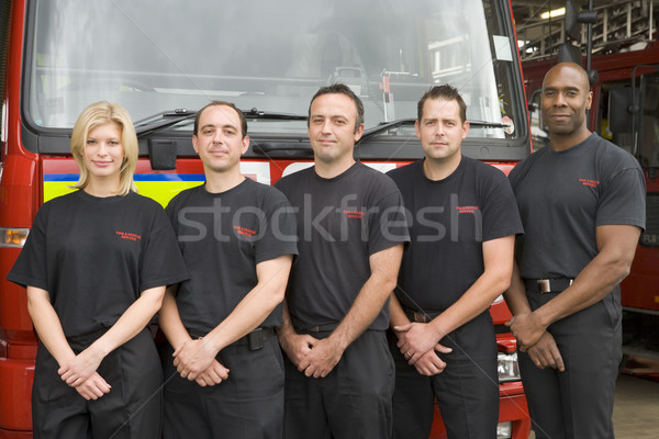 Stock photo: Portrait of firefighters standing by a fire engine