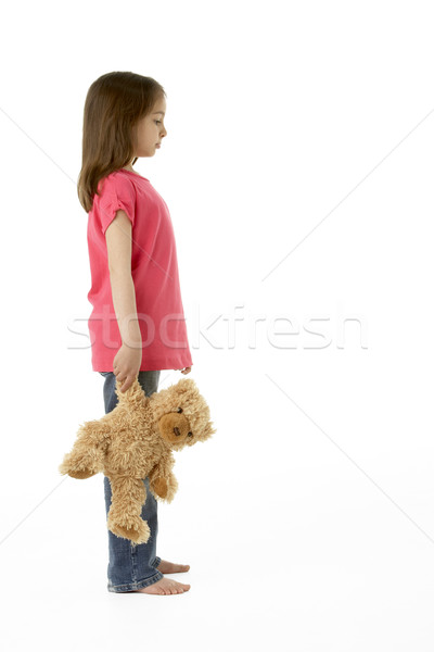 Stock photo: Studio Portrait of Girl Standing with Teddy Bear