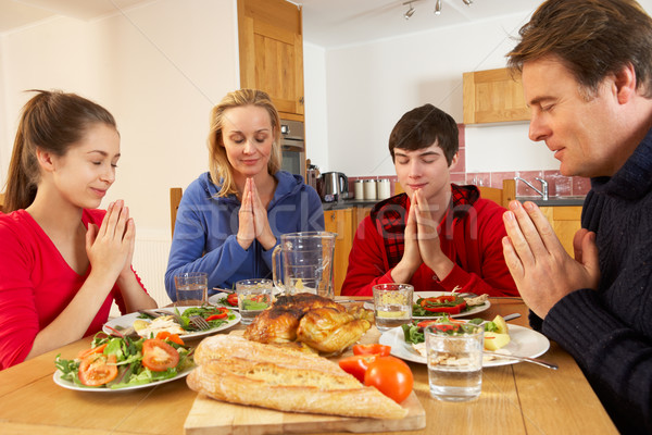 Teenage Family Saying Grace Before Eating Lunch Together In Kitc Stock photo © monkey_business