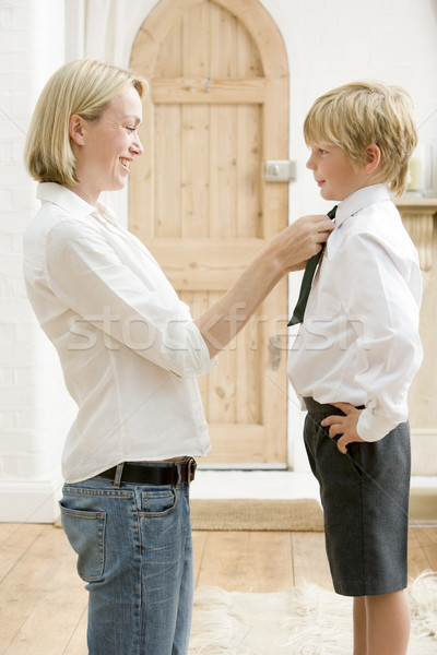Woman in front hallway fixing young boy's tie and smiling Stock photo © monkey_business