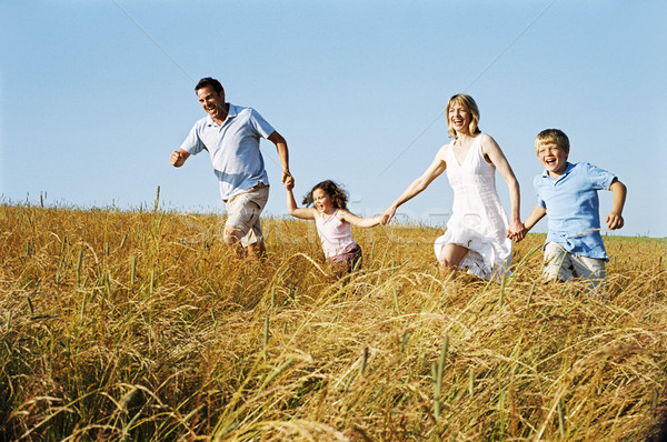 Family running outdoors holding hands smiling Stock photo © monkey_business