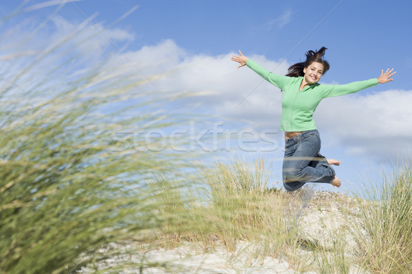 Fiatal nő ugrik homok levegő nő fű Stock fotó © monkey_business