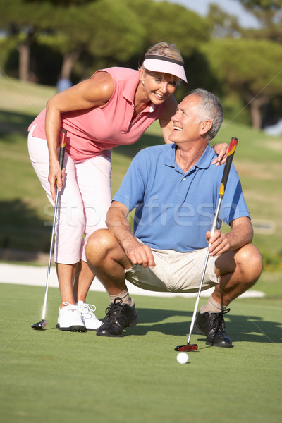 Senior Couple Golfing On Golf Course Lining Up Putt On Green Stock photo © monkey_business