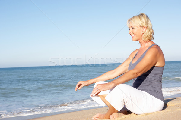 Kıdemli kadın uygunluk giyim meditasyon plaj Stok fotoğraf © monkey_business