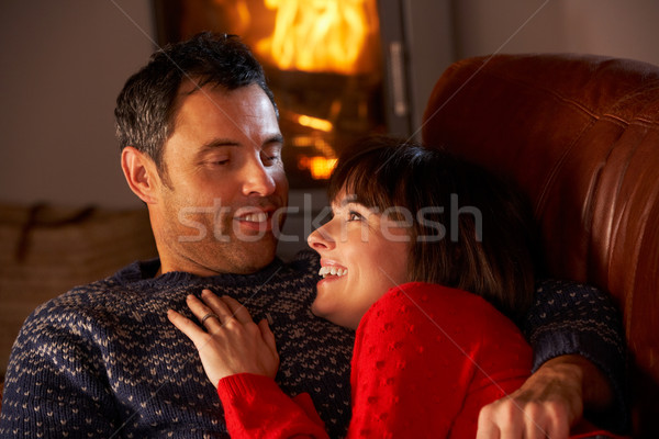 Middle Aged Couple Chatting On Sofa By Cosy Log Fire Stock photo © monkey_business