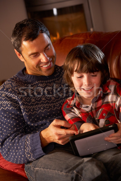Father And Son Using Tablet Computer By Cosy Log Fire Stock photo © monkey_business