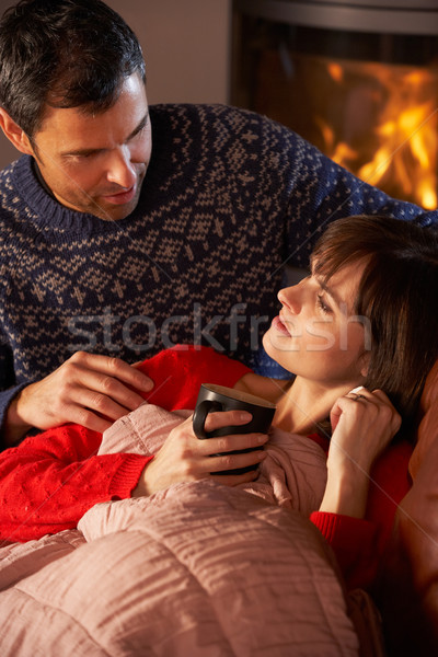 Husband Nursing Sick Wife With Cold Resting On Sofa By Cosy Log  Stock photo © monkey_business