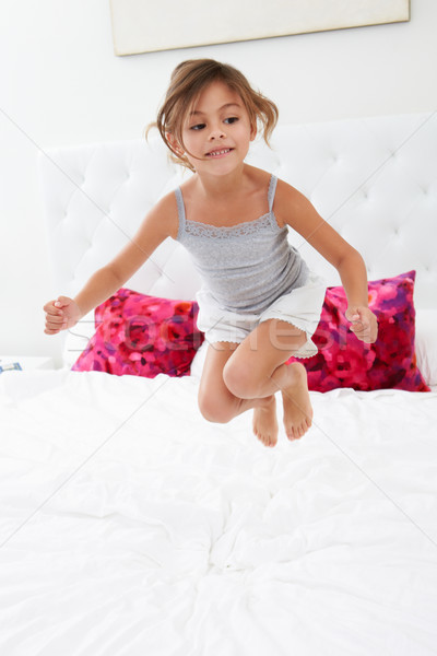 Girl Jumping On Bed Wearing Pajamas Stock photo © monkey_business