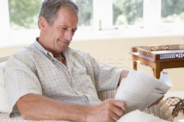 Man woonkamer lezing krant glimlachend stoel Stockfoto © monkey_business