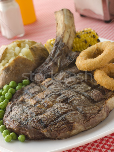Ribeye Steak on the bone with Baked Potato Peas Onion Rings and  Stock photo © monkey_business