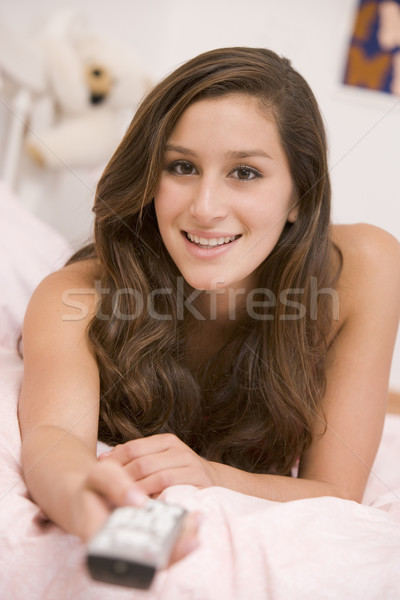 Teenage Girl Lying On Her Bed Changing Television Channels Stock photo © monkey_business