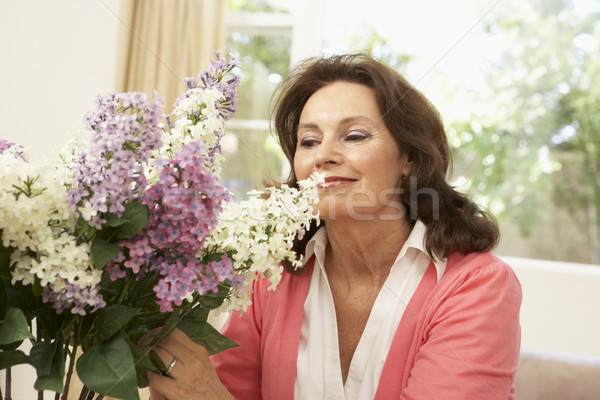 Stock photo: Senior Woman At Home Arranging Flowers