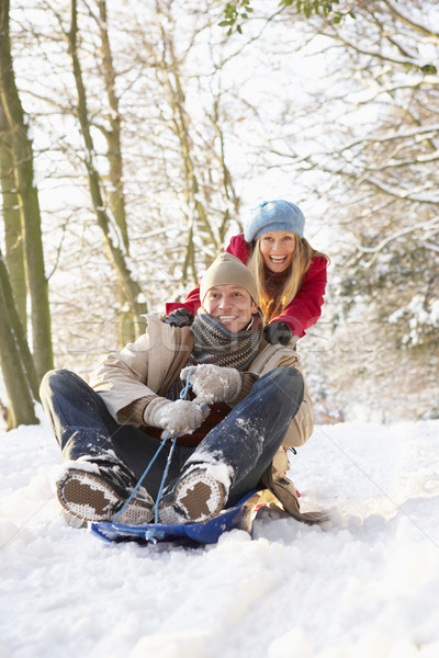 Couple Sledging Through Snowy Woodland Stock photo © monkey_business