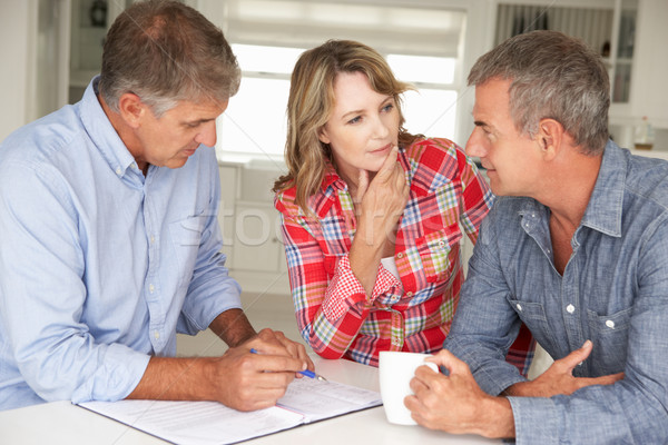 Mid age couple with financial advisor at home Stock photo © monkey_business