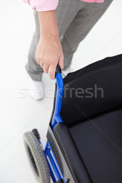 Woman pushing empty wheelchair Stock photo © monkey_business