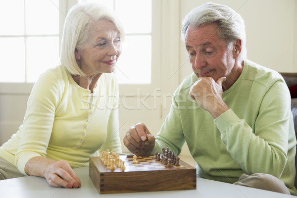 Stock photo: Couple playing chess in living room smiling