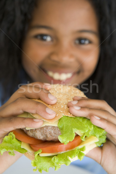 Young girl eating cheeseburger smiling Stock photo © monkey_business