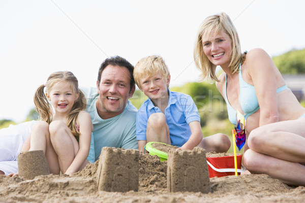 Stock photo: Family on beach making sand castles smiling