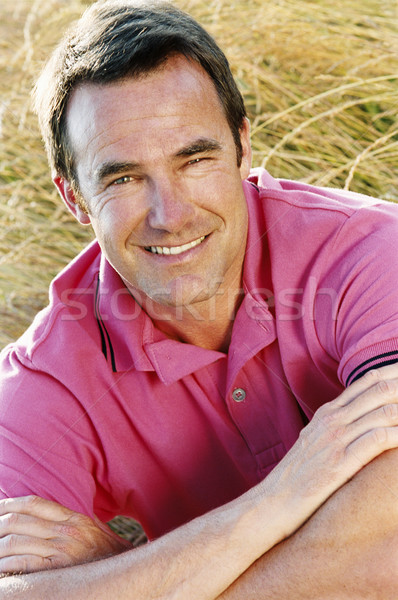 Stock photo: Man sitting outdoors smiling