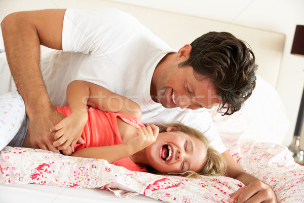 Stock photo: Father And Daughter Relaxing Together In Bed