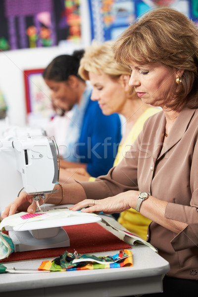 Stock photo: Group Of Women Using Electric Sewing Machines In class