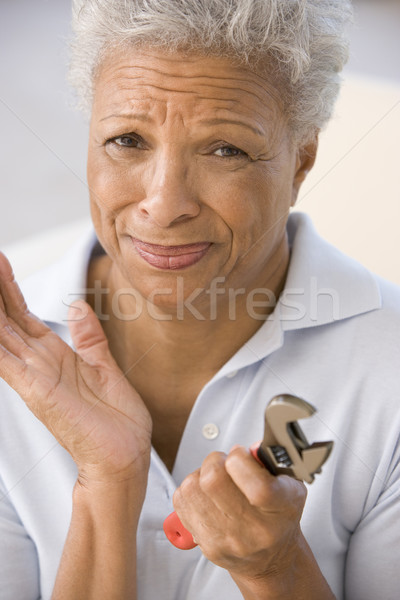 Woman holding wrench looking unsure Stock photo © monkey_business