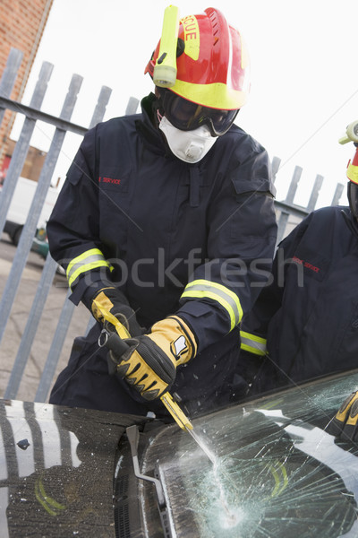 Firefighters breaking a car windscreen to help a car crash victi Stock photo © monkey_business