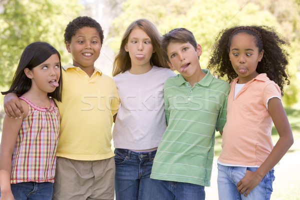 Stock photo: Five young friends standing outdoors making funny faces