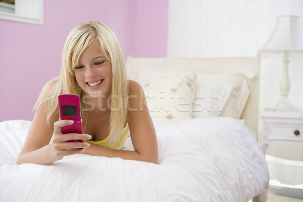 Teenage Girl Lying On Bed Using Mobile Phone  Stock photo © monkey_business
