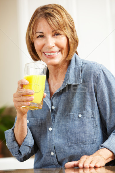 Mid age woman drinking orange juice Stock photo © monkey_business