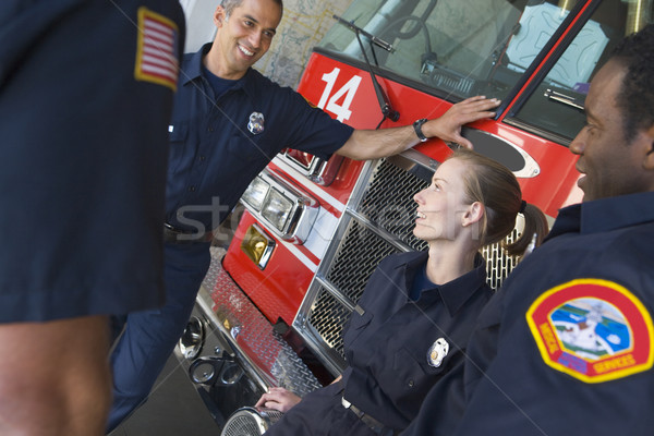 Firefighters chatting by a fire engine Stock photo © monkey_business