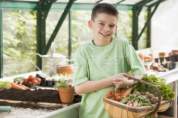 Young boy in greenhouse holding basket of vegetables smiling Stock photo © monkey_business