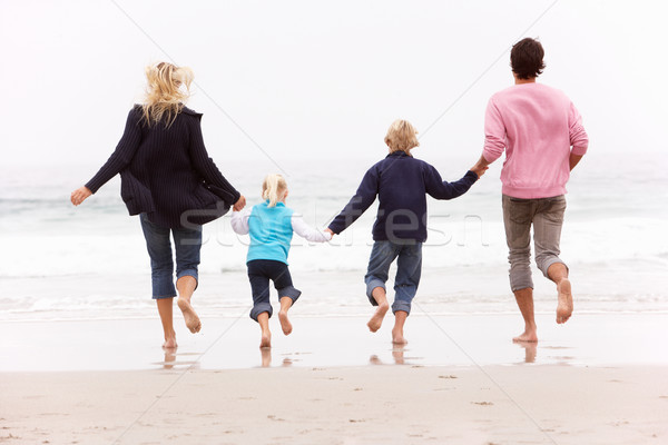 Back View Of Young Family Running Along Winter Beach Stock photo © monkey_business