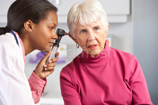 Stock photo: Doctor Examining Senior Female Patient's Ears