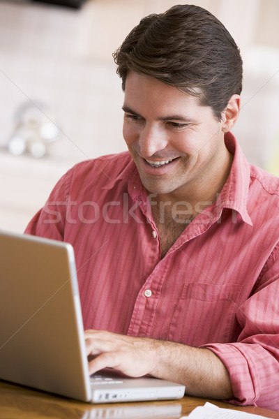Foto stock: Homem · cozinha · usando · laptop · sorridente · computador · internet