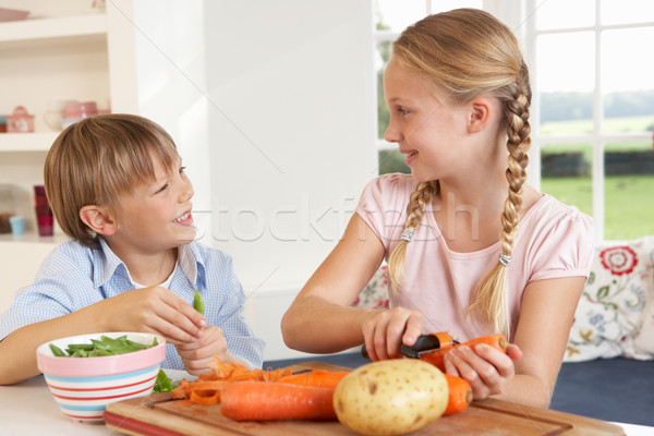 Happy children peeling vegetables in kitchen Stock photo © monkey_business