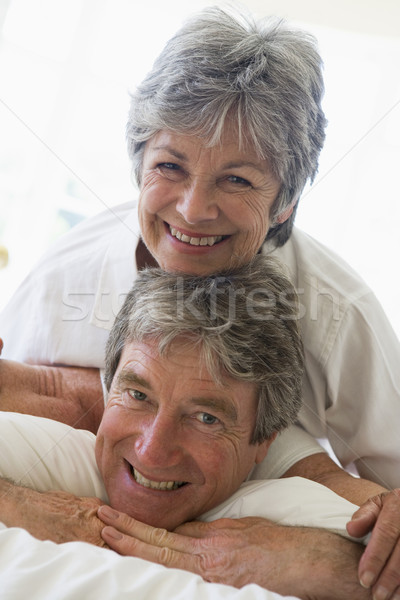 Stock photo: Couple relaxing in bedroom and smiling