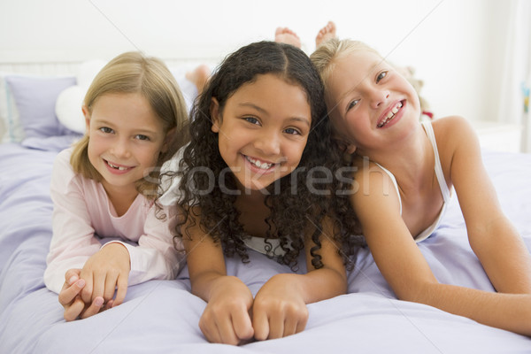 Three Young Girls Lying On A Bed In Their Pajamas Stock photo © monkey_business