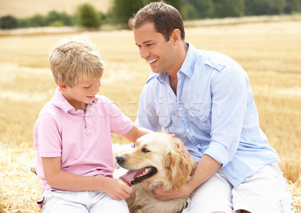 Father And Son Sitting With Dog On Straw Bales In Harvested Fiel Stock photo © monkey_business