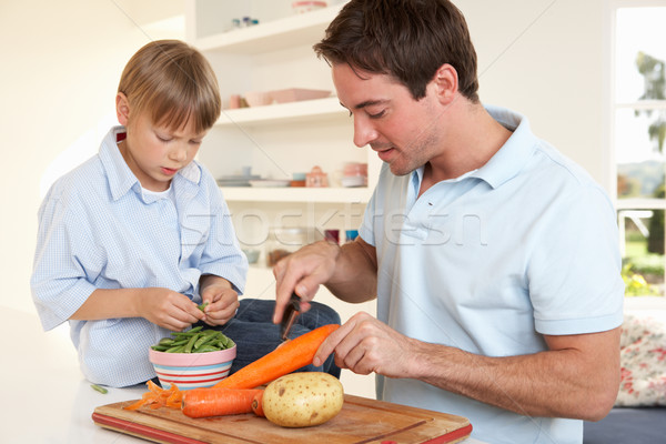 Happy young man with boy peeling vegetables in kitchen Stock photo © monkey_business