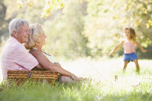Grandparents at a picnic with young girl in background dancing Stock photo © monkey_business