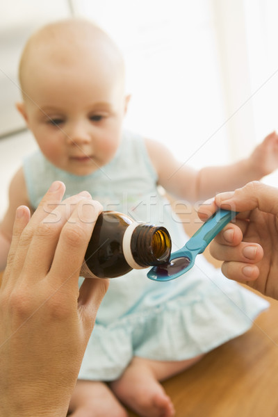 Mother giving baby medicine indoors Stock photo © monkey_business