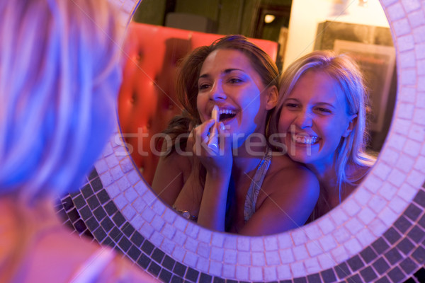 Two young women applying makeup in a nightclub bathroom Stock photo © monkey_business