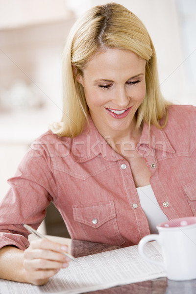 Woman in kitchen with newspaper and coffee smiling Stock photo © monkey_business
