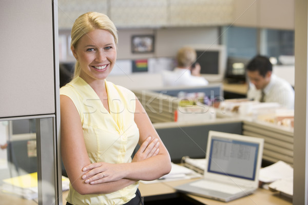 Stock photo: Businesswoman standing in cubicle smiling