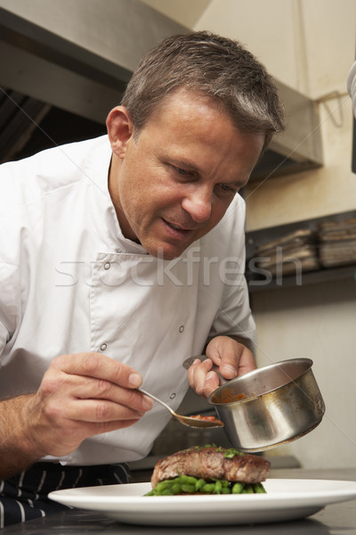 Chef Adding Sauce To Dish In Restaurant Kitchen Stock photo © monkey_business
