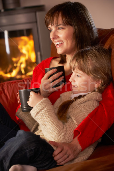 Mother And Daughter Relaxing With Hot Drink Watching TV By Cosy  Stock photo © monkey_business