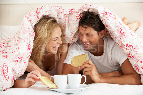 Couple Snuggled Under Duvet Eating Breakfast Stock photo © monkey_business