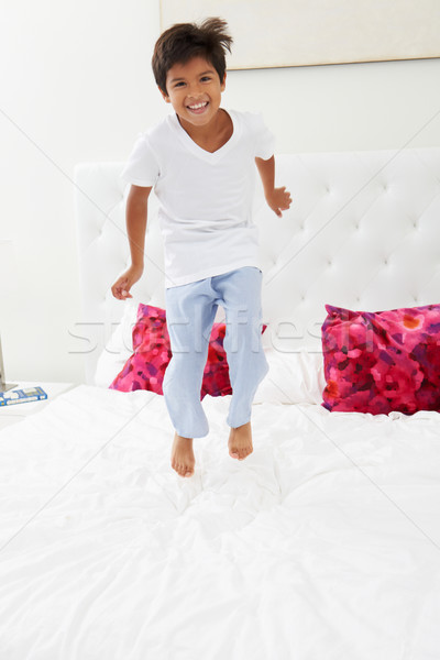 Boy Jumping On Bed Wearing Pajamas Stock photo © monkey_business