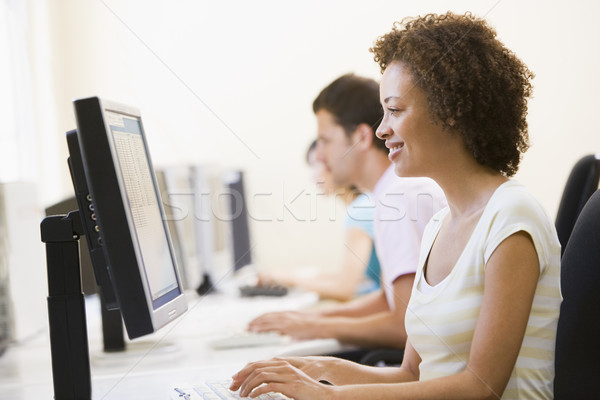 Três pessoas sessão sala de informática datilografia sorridente negócio Foto stock © monkey_business